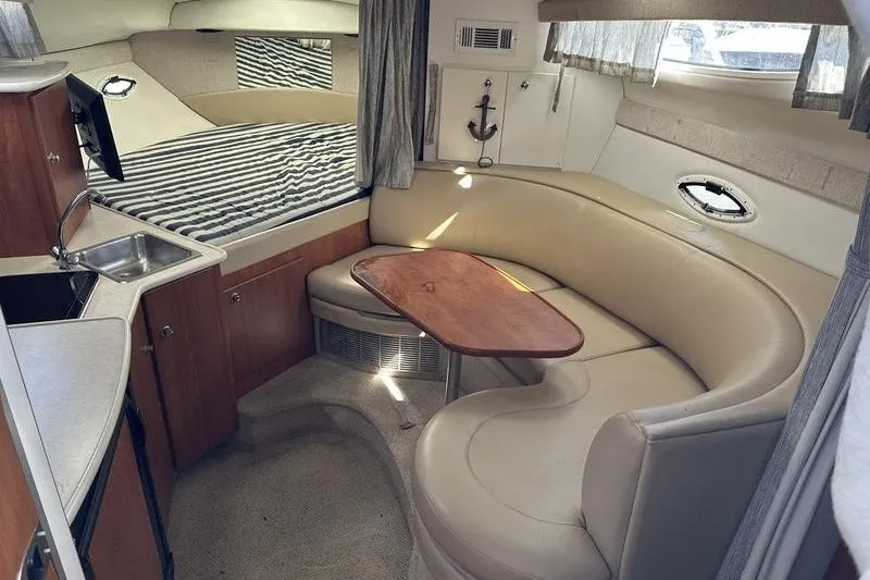 Slide: The Image of 2004 Bayliner 3055 Ciera Sunbridge interior with cozy seating and compact kitchen area. - 33