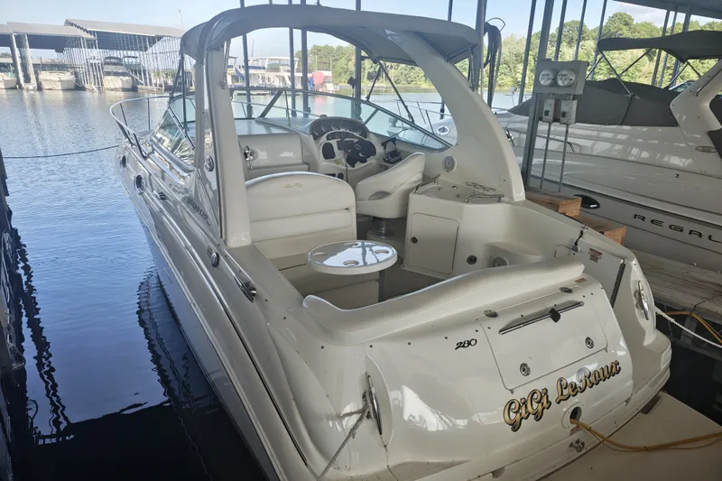 Slide: The Image of 2002 Sea Ray Sundancer 280 docked in a marina, showcasing its sleek design and spacious cockpit. - 6