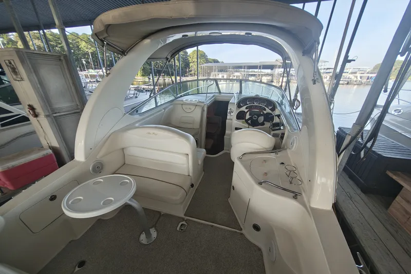 Slide: The Image of 2002 Sea Ray Sundancer 280 boat interior with seating and helm, docked at marina. - 7