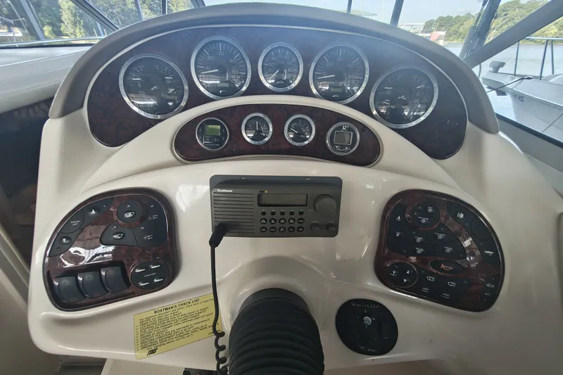 Slide: The Image of 2002 Sea Ray Sundancer 280 dashboard with gauges and controls, featuring a Raytheon marine radio. - 9