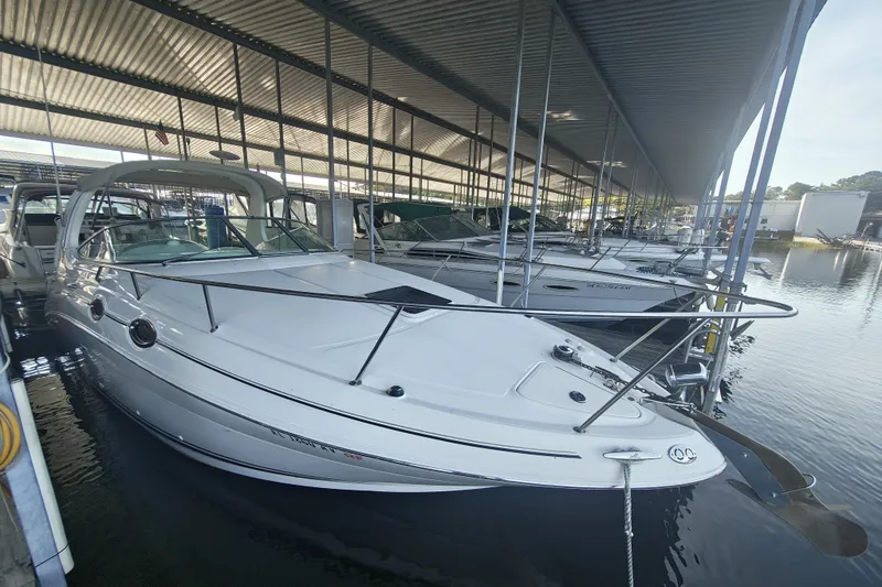 Slide: The Image of 2002 Sea Ray Sundancer 280 docked in a covered marina, showcasing sleek design and white exterior. - 3