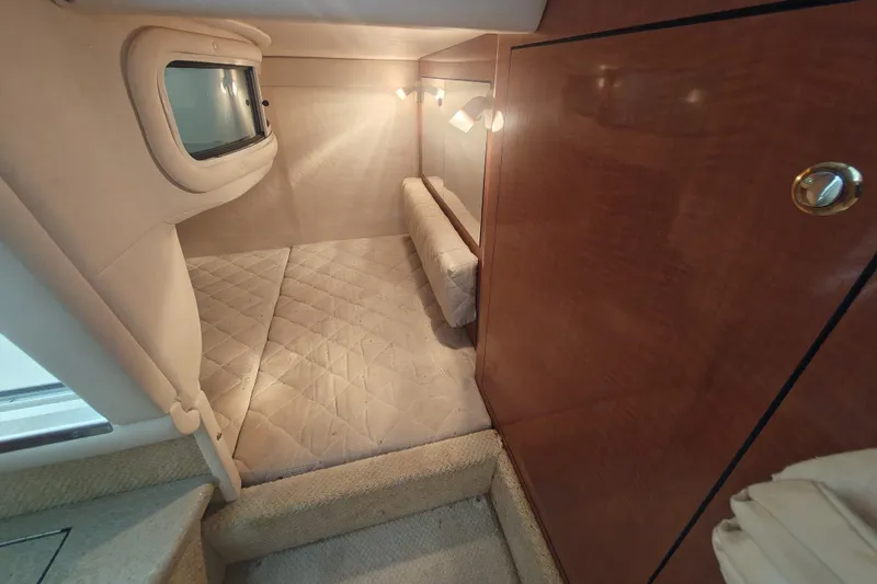 Slide: The Image of Interior cabin of 2002 Sea Ray Sundancer 280 with cozy bed and wooden paneling. - 15