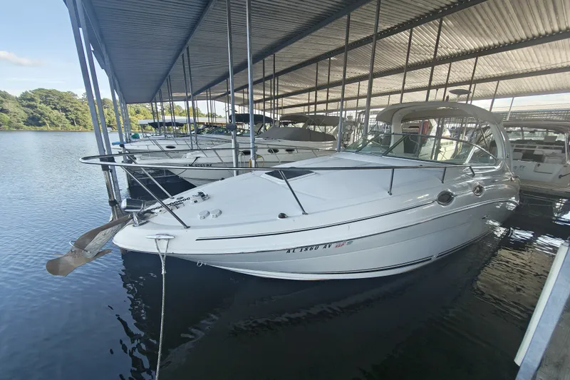 The Image of 2002 Sea Ray Sundancer 280 docked in a marina under a covered shelter. - 1