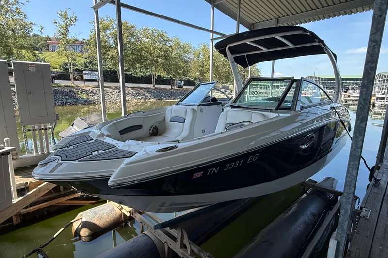 Slide: The Image of 2014 Chaparral 224 Sunesta boat docked under a covered marina. - 2