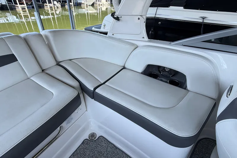 Slide: The Image of Interior seating of a 2014 Chaparral 224 Sunesta boat, featuring white and gray upholstery. - 12