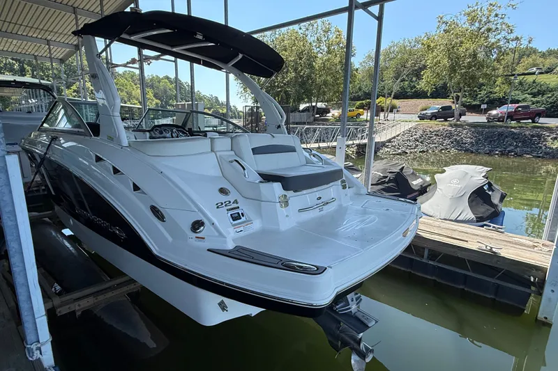 Slide: The Image of 2014 Chaparral 224 Sunesta boat docked in a marina, featuring sleek design and spacious deck. - 4