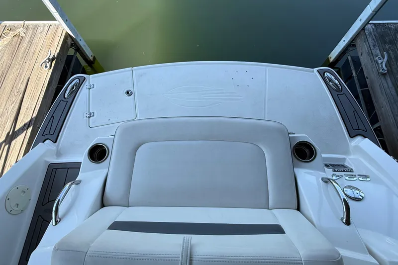 Slide: The Image of 2014 Chaparral 224 Sunesta boat interior with seating and cup holders at dock. - 7
