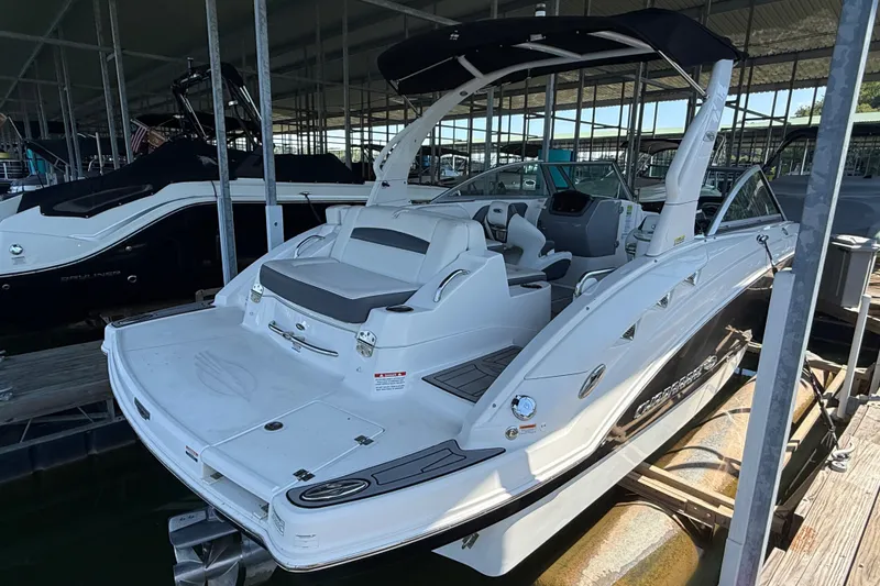 Slide: The Image of 2014 Chaparral 224 Sunesta boat docked in a marina, featuring sleek design and spacious seating. - 5