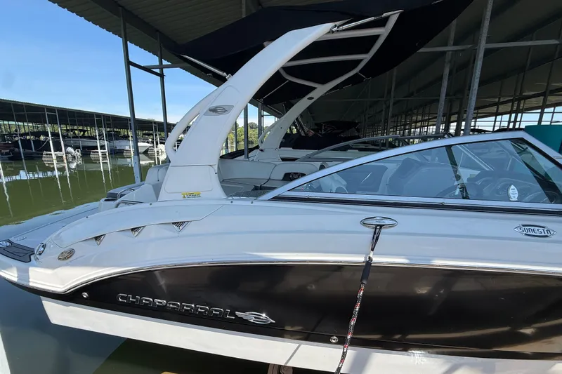 Slide: The Image of 2014 Chaparral 224 Sunesta boat docked in a marina under a covered shelter. - 6