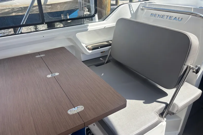 Slide: The Image of Interior of 2025 Beneteau Antares 8 with foldable table and cushioned seating. - 24
