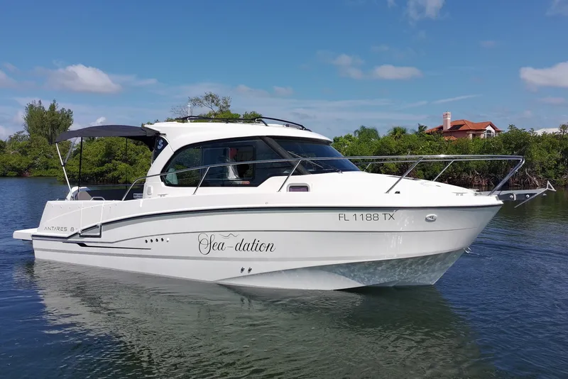 The Image of The 2025 Beneteau Antares 8 is a sleek motorboat with a white hull and shaded canopy. - 0