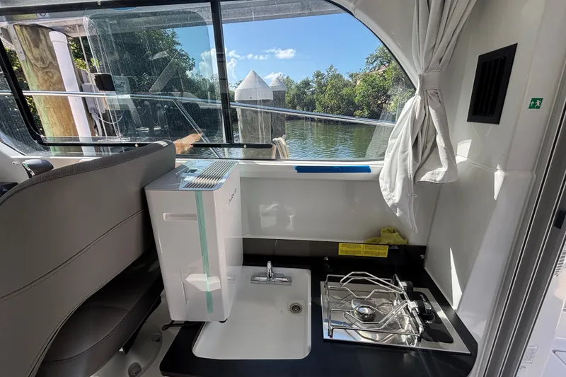 Slide: The Image of Interior of 2025 Beneteau Antares 8 boat with kitchenette and scenic window view. - 26