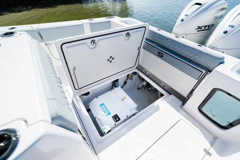 Slide: The Image of 2027 Sportsman Open 232 Center Console boat with open storage compartment and twin engines. - 36