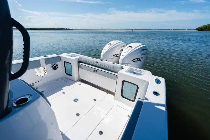 Slide: The Image of 2027 Sportsman Open 232 Center Console boat with twin Yamaha engines on calm water. - 14