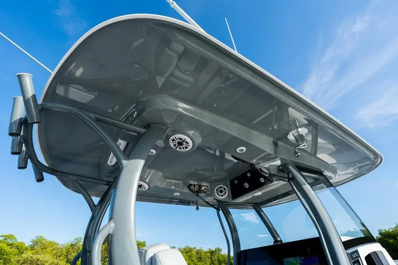 Slide: The Image of 2027 Sportsman Open 232 Center Console boat with sleek T-top design under clear blue sky. - 24