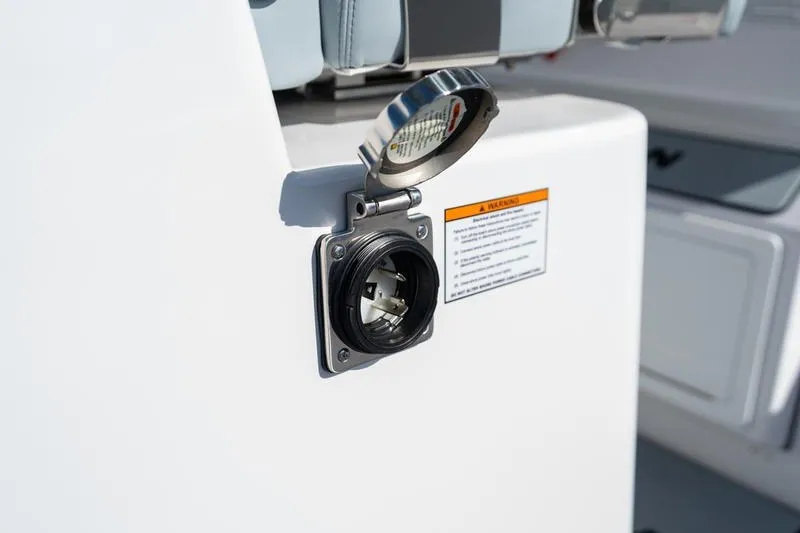 Slide: The Image of 2027 Sportsman Open 232 Center Console power outlet with protective cover. - 29