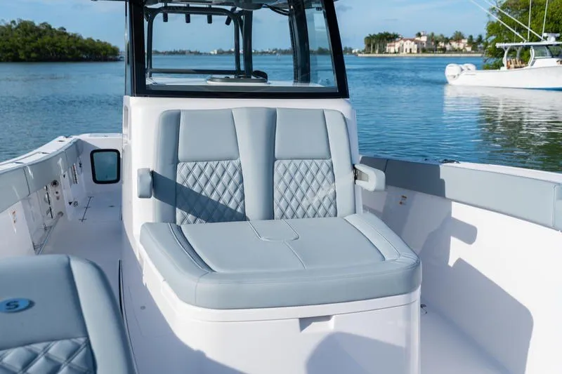 Slide: The Image of 2027 Sportsman Open 232 Center Console boat with luxurious seating on calm water. - 17