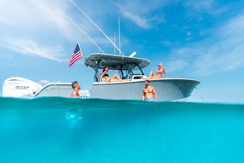 Slide: The Image of 2027 Sportsman Open 232 Center Console boat with people enjoying the ocean. - 0