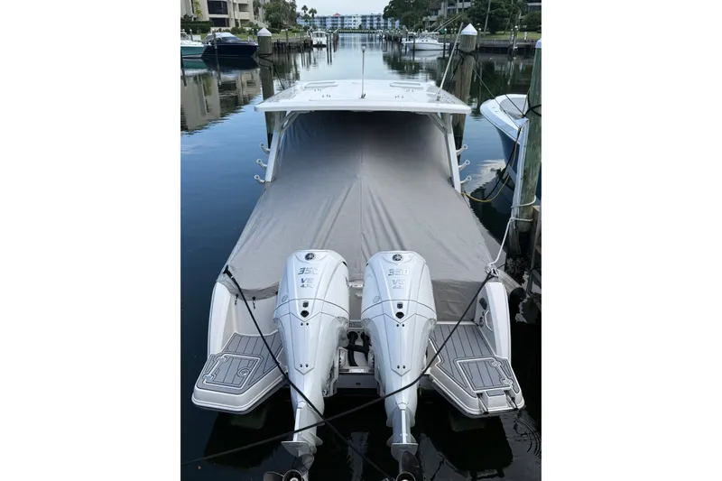 Slide: The Image of 2026 Sailfish 316 DC boat with dual outboard engines docked, covered with a protective tarp. - 4