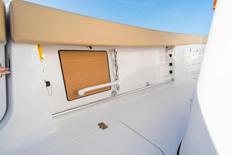 Slide: The Image of 2027 Sportsman Open 352 Center Console interior detail with storage compartment and beige seating. - 43