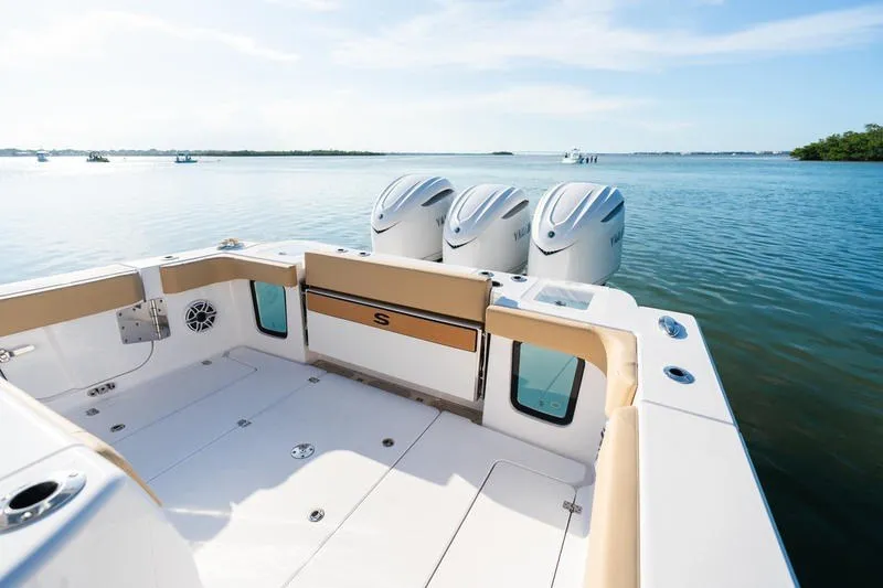 Slide: The Image of 2027 Sportsman Open 352 Center Console boat with triple engines on calm water. - 20