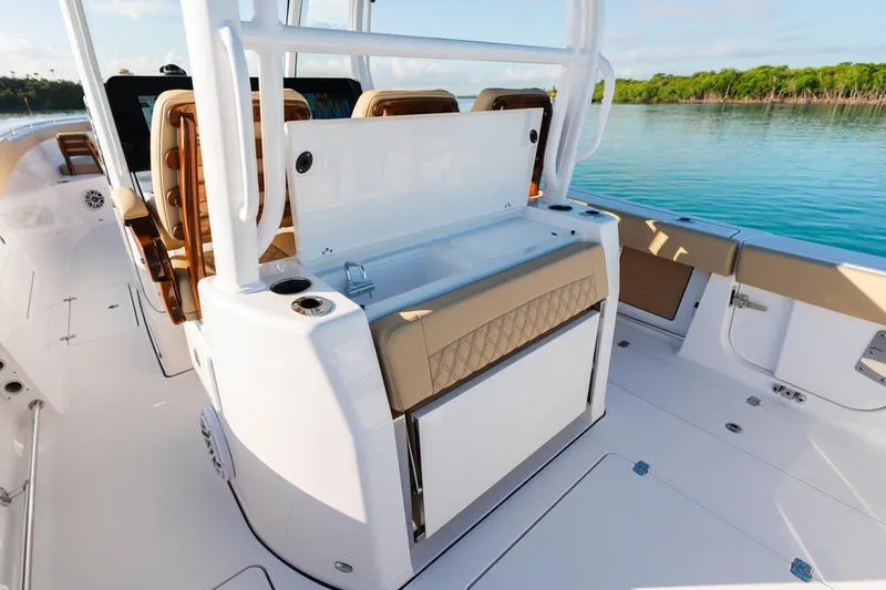 Slide: The Image of 2027 Sportsman Open 352 Center Console boat interior with seating and storage, near calm waters. - 44