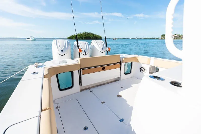 Slide: The Image of 2027 Sportsman Open 352 Center Console boat on calm water, featuring fishing rods and engines. - 15