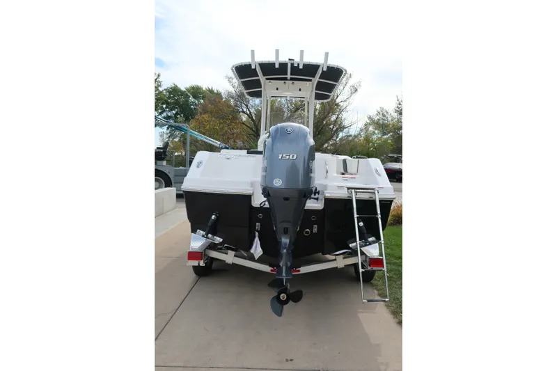 Slide: The Image of 2023 Robalo R202 Explorer boat with outboard motor and ladder, parked outdoors. - 6