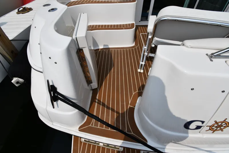 Slide: The Image of 1998 Sea Ray 400 Sedan Bridge boat deck with wood-style flooring and railing. - 13