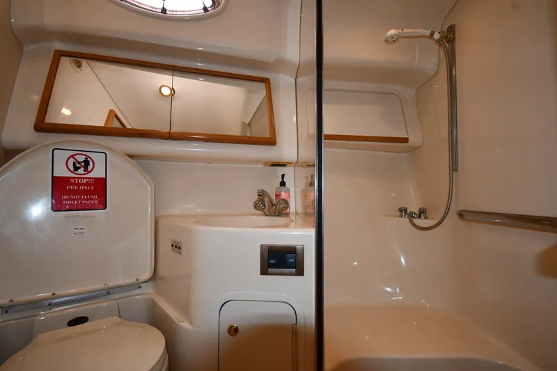 Slide: The Image of 1998 Sea Ray 400 Sedan Bridge bathroom with shower, mirror, and toilet. - 55