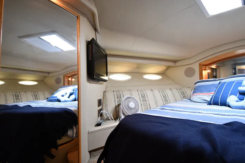 Slide: The Image of Cozy bedroom interior of 1998 Sea Ray 400 Sedan Bridge yacht with striped bedding. - 31