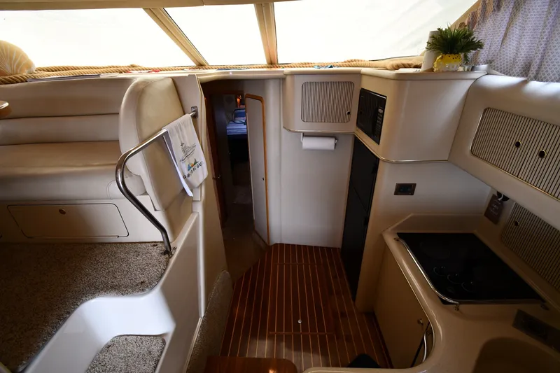 Slide: The Image of Interior of a 1998 Sea Ray 400 Sedan Bridge yacht, featuring a cozy kitchen and seating area. - 27