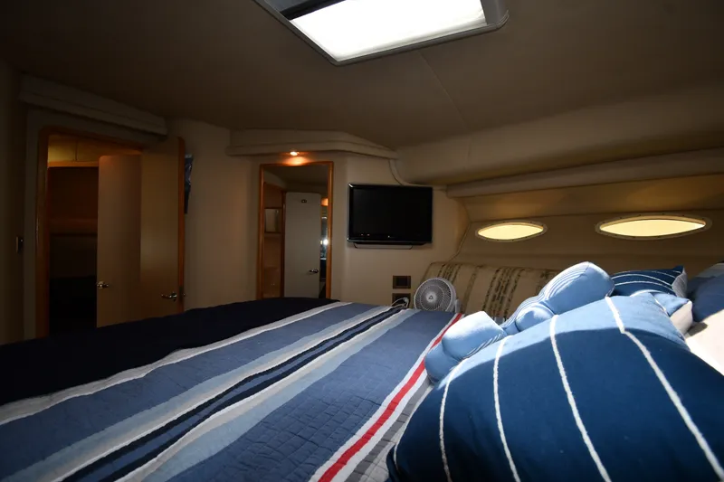 Slide: The Image of Cozy bedroom interior of 1998 Sea Ray 400 Sedan Bridge yacht with striped bedding. - 32