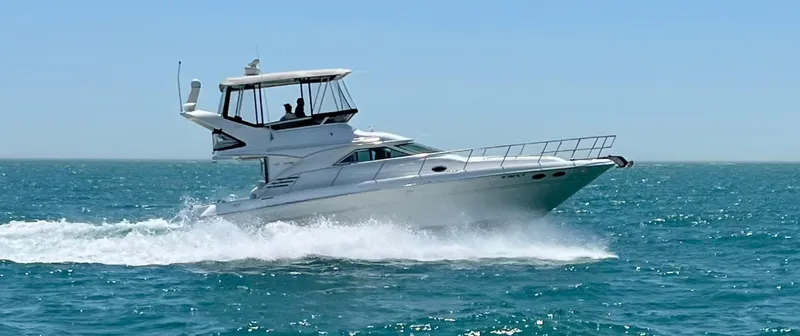 The Image of A 1998 Sea Ray 400 Sedan Bridge cruising swiftly over the blue sea. - 0
