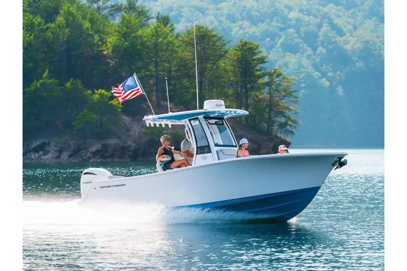 The Image of 2027 Sportsman Heritage 231 Center Console boat cruising on a scenic lake. - 1