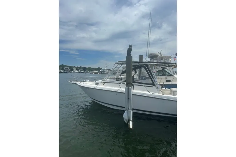The Image of Century 3200 Center Console boat docked on a calm, cloudy day, 2000 model. - 1