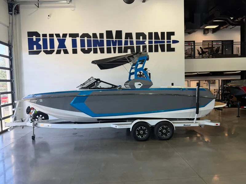 The Image of A blue and gray boat on a trailer in a showroom. It features a modern design. - 1