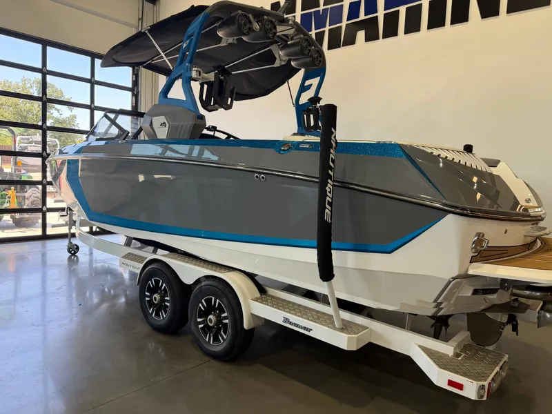 Slide: The Image of A 2019 Nautique Super Air Nautique G25 on a trailer in a showroom. - 2