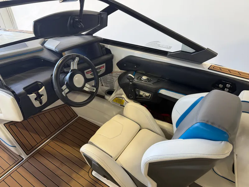 Slide: The Image of The image shows the cockpit of a 2019 Nautique Super Air Nautique G25 with luxurious seating and wood trim. - 8