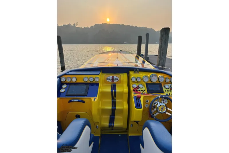 Slide: The Image of 2005 Cigarette 39' Top Gun Unlimited boat dashboard at sunset on a serene lake. - 17