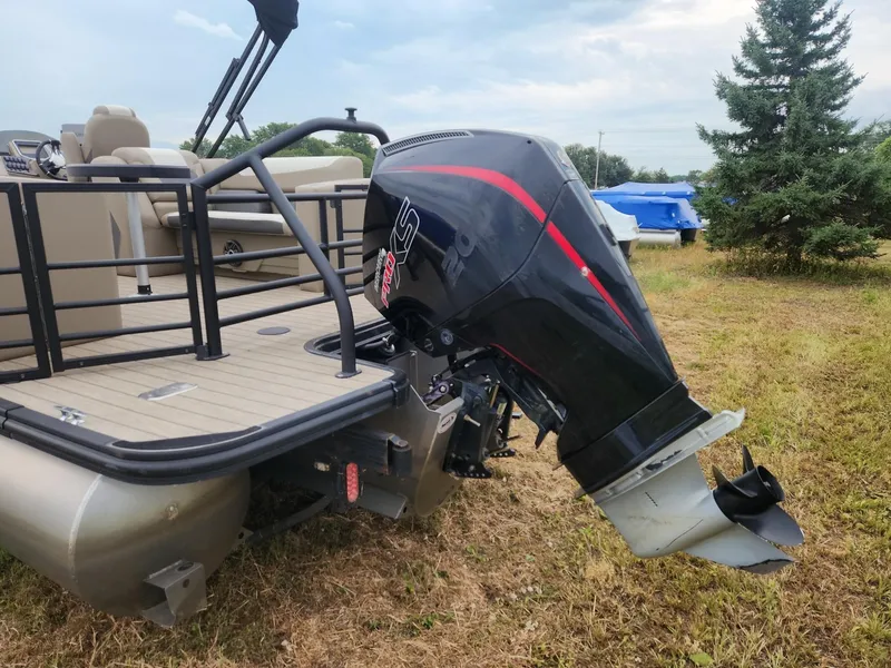 Slide: The Image of A 2023 SunChaser Eclipse 8523 LR DH with an outboard motor, parked on grassy terrain. - 6