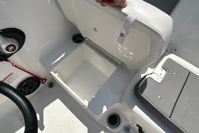 Slide: The Image of 2022 Tahoe T16 boat interior storage compartment with open seat and cup holders. - 14