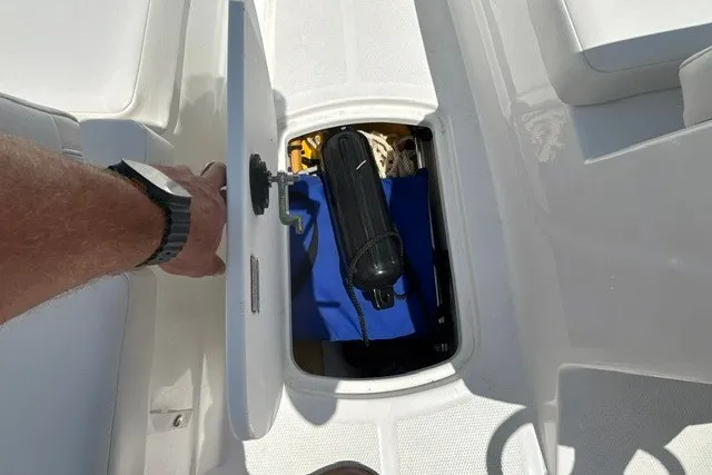 Slide: The Image of Open storage compartment on 2022 Tahoe T16 boat, showing equipment and accessories. - 20