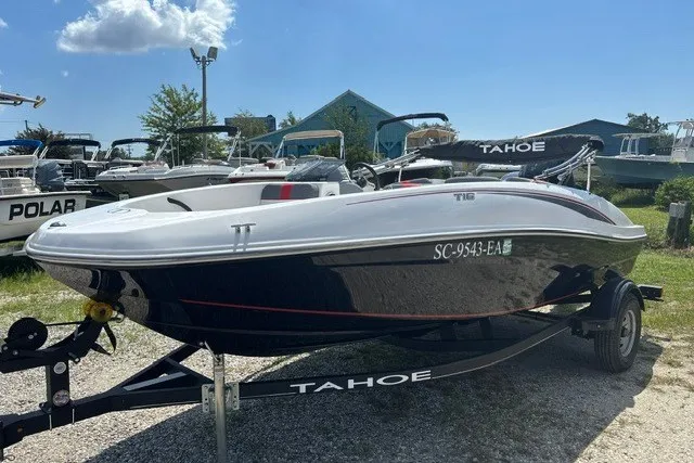 The Image of 2022 Tahoe T16 boat on trailer, parked outdoors under a clear sky. - 1