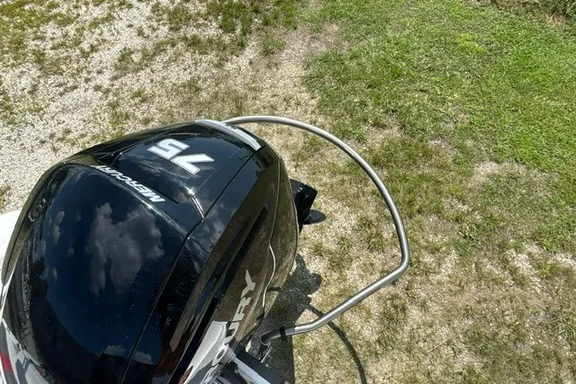 Slide: The Image of Outboard motor on a 2022 Tahoe T16 boat, parked on grassy terrain. - 21