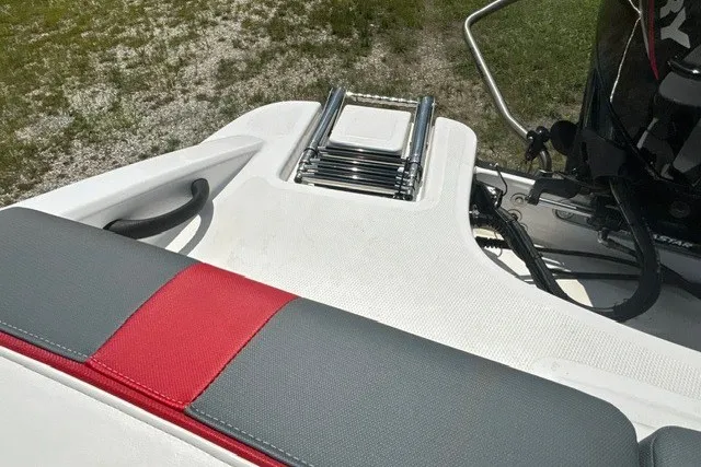 Slide: The Image of 2022 Tahoe T16 boat with red and gray seating, ladder, and motor detail. - 25