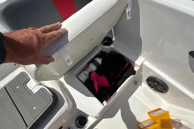 Slide: The Image of Open storage compartment in a 2022 Tahoe T16 boat, revealing life jacket and supplies. - 26