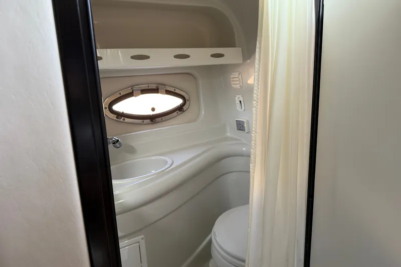 Slide: The Image of 2005 Crownline 275 CCR boat bathroom with porthole window and compact design. - 17