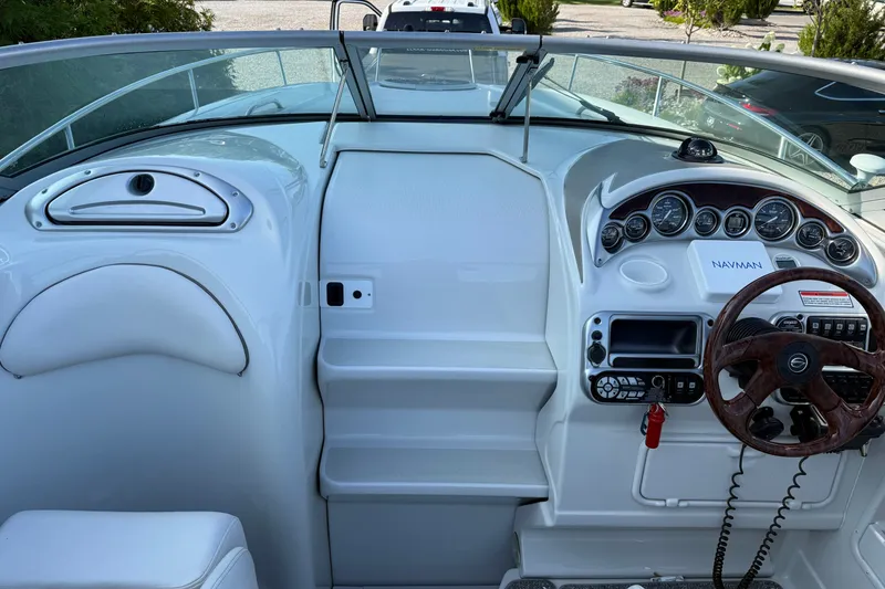 Slide: The Image of 2005 Crownline 275 CCR boat dashboard with steering wheel and navigation instruments. - 14