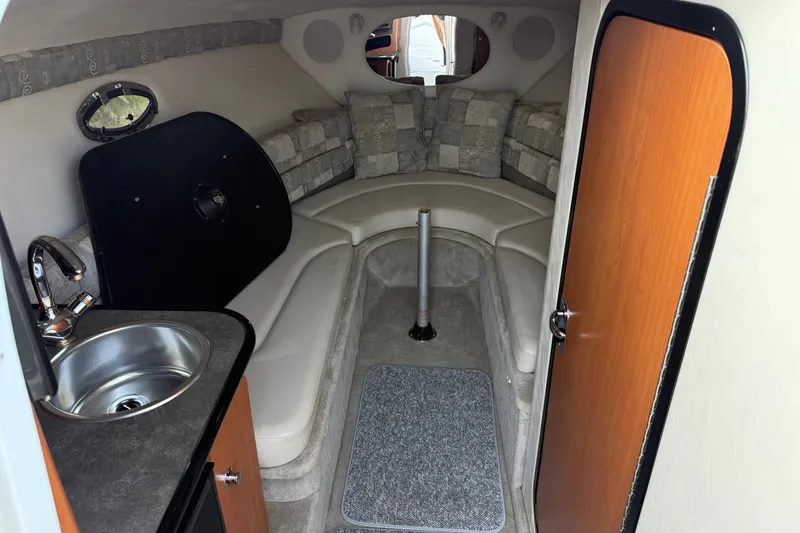 Slide: The Image of 2005 Crownline 275 CCR cabin interior with sink, seating, and wood accents. - 15